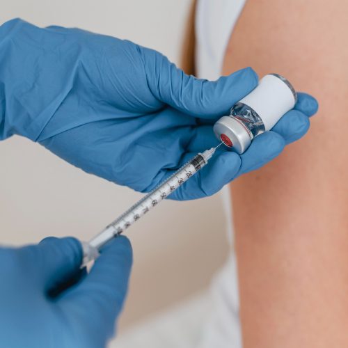 doctor-with-gloves-preparing-syringe-with-vaccine